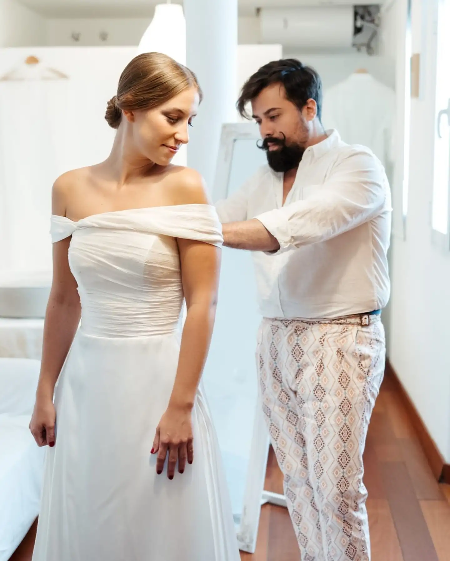 Mario Valladares colocando un traje a una novia