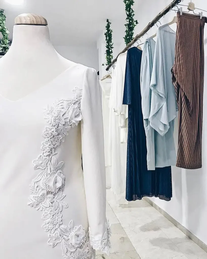 Traje blanco en primer plano y otras prendas al fondo