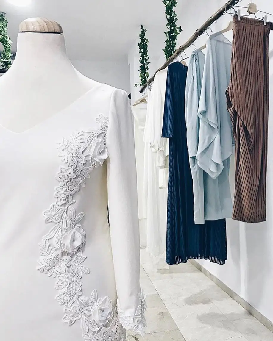 Traje blanco en primer plano y otras prendas colgadas detrás